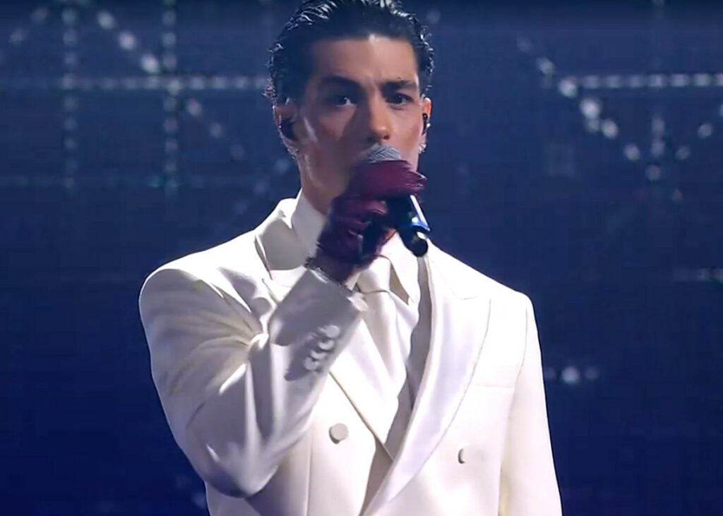 Tony Effe con il look total white a Sanremo sale sul palco con tutti i tatuaggi coperti: guarda